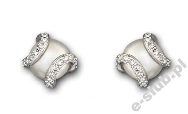 Suknia, welon, rękawiczki – Cymbeline. Komplet bielizny ślubnej – Panache. Zestaw biżuterii (kolczyki, łańcuszek z przywieszką, pierścionek) – Swarovski. Obrączki ślubne (damska z brylantem) – Apart. Pantofelek na wysokiej szpilce – DeeZee. Wiązanka ślubna – Katarzyna Sielska, Kwiaciarnia „Zosieńka”.  Ślubna stylizacja paznokci – Studio Urody Venus.